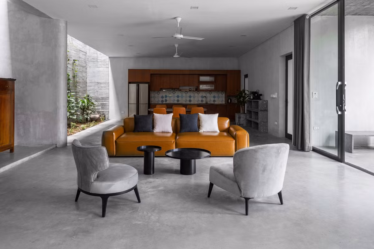 Với sự yêu thích bê tông của gia chủ, nhóm thiết kế chọn vật liệu hoàn thiện nhà chủ yếu là bê tông với bề mặt nhám, gỗ màu hạt dẻ giúp không gian trở nên ấm cúng hơn.