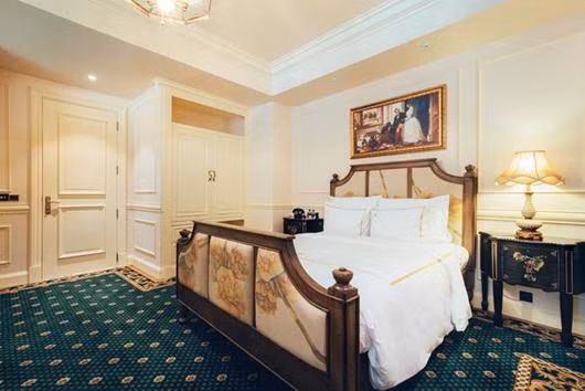 Phòng ngủ được lát nền bằng thảm xanh họa tiết quý tộc.