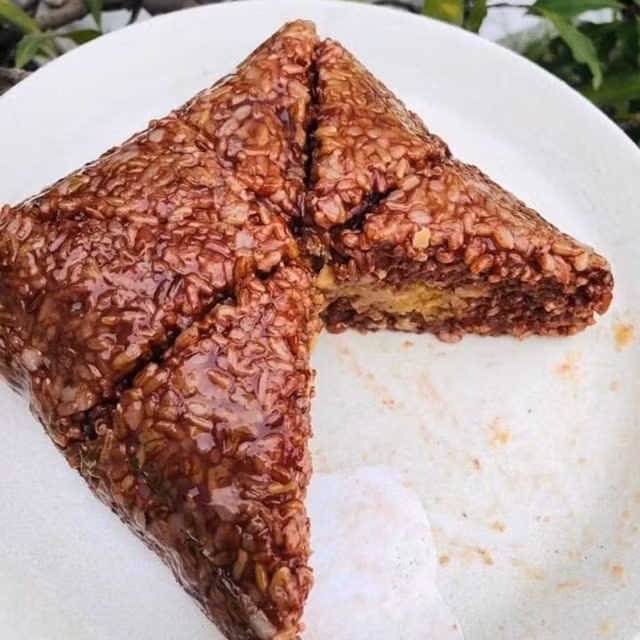 Bánh chưng gạo lứt có cách chế biến tương tự bánh chưng truyền thống. Tuy nhiên, thay vì gạo trắng, vỏ bánh được làm bằng gạo lứt. Giá của loại bánh này là từ 55.000 - 100.000 đồng/chiếc, tùy trọng lượng. Ảnh: Facebook.