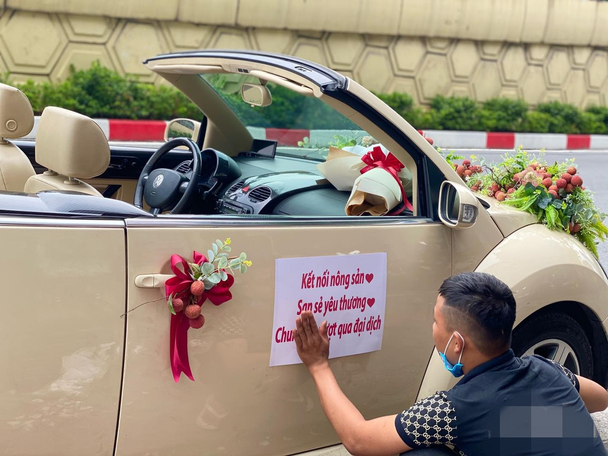 Chiếc xe mui trần màu trắng sang trọng được trang trí rất cầu kì bởi hoa, lá và vải thiều. Ảnh: Hoàng Minh Hùng