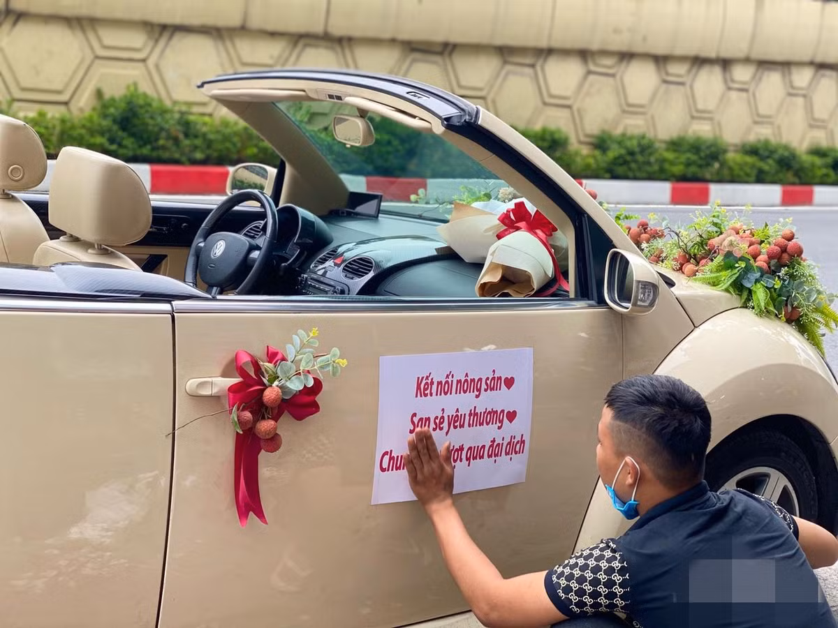 Chiếc xe mui trần màu trắng sang trọng được trang trí rất cầu kì bởi hoa, lá và vải thiều. Ảnh: Hoàng Minh Hùng