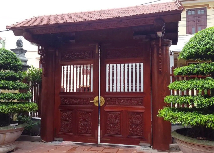 Với nhà cao tầng, gỗ là chất liệu được nhiều người lựa chọn khi trang trí cổng bởi gỗ thể hiện sự giàu sang, phú quý mà gia chủ mong muốn.
