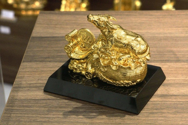 Tượng trâu mạ vàng Nghênh Phúc (dài 32cm) được nghệ nhân thiết kế và chế tác với dáng trâu nằm trên bao tiền mang ý nghĩa cầu tài lộc, may mắn trong năm Tân Sửu 2021 có giá 35 triệu đồng. Ảnh: Karalux