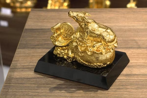 Tượng trâu mạ vàng Nghênh Phúc (dài 32cm) được nghệ nhân thiết kế và chế tác với dáng trâu nằm trên bao tiền mang ý nghĩa cầu tài lộc, may mắn trong năm Tân Sửu 2021 có giá 35 triệu đồng. Ảnh: Karalux