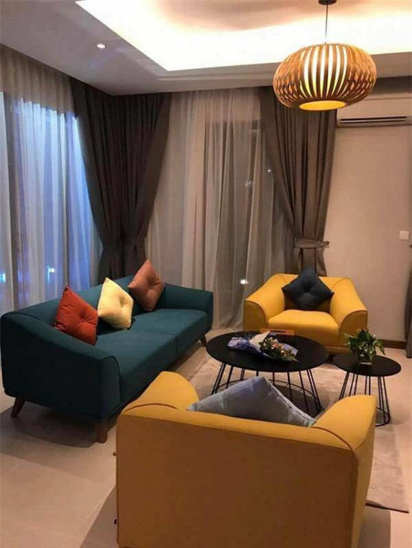 Phòng khách trẻ trung sang trọng với sofa lớn màu xanh và 2 sofa đơn nhỏ. Ảnh: FBNV
