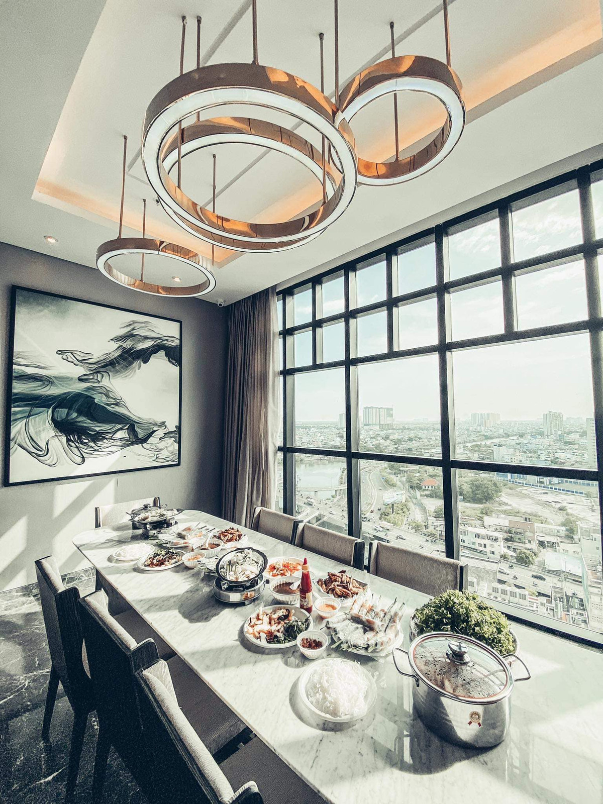 Nhà bếp và bàn ăn được ốp đá, đèn thả trần sang trọng.