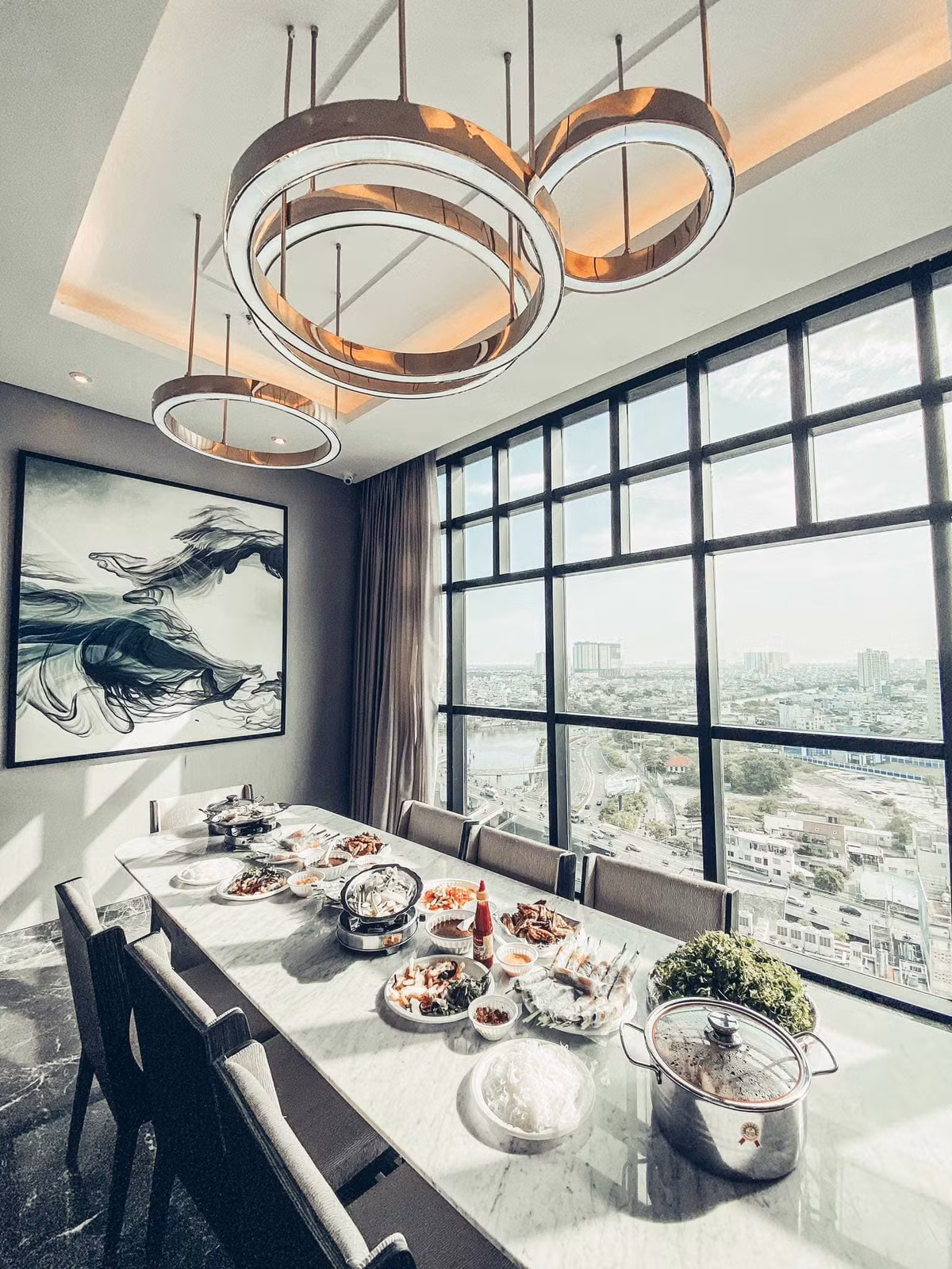 Nhà bếp và bàn ăn được ốp đá, đèn thả trần sang trọng.