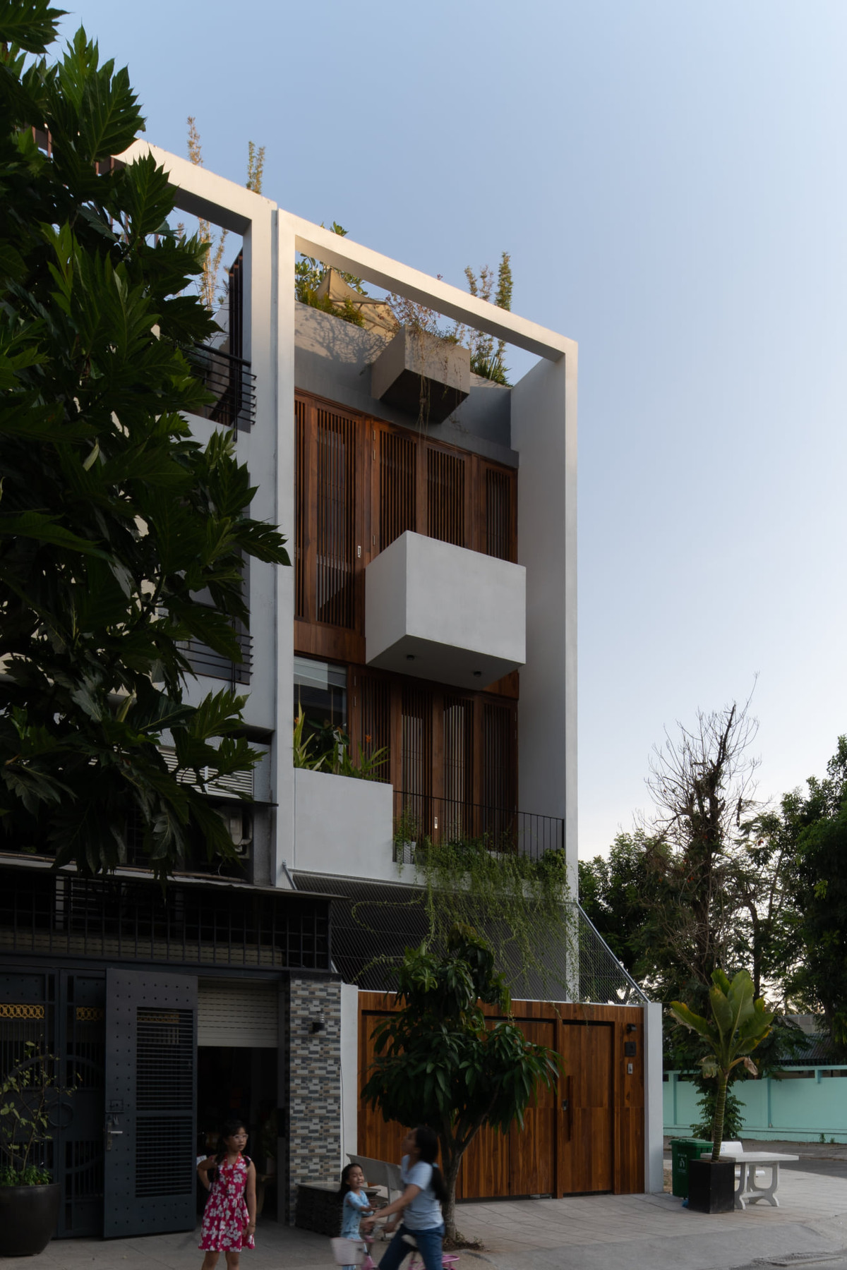 Do nhà hướng Tây Bắc nên giải pháp hệ cửa lam gỗ xuyên suốt mặt đứng giúp hạn chế ánh nắng trực diện kết hợp hệ cửa kính bên trong.