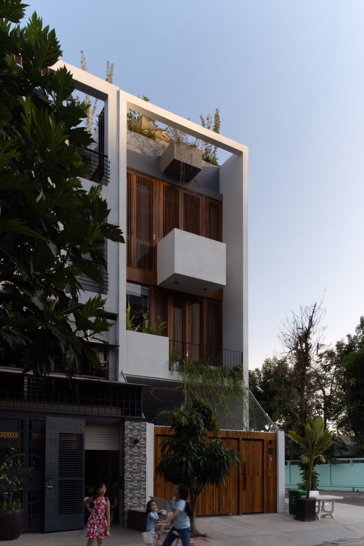 Do nhà hướng Tây Bắc nên giải pháp hệ cửa lam gỗ xuyên suốt mặt đứng giúp hạn chế ánh nắng trực diện kết hợp hệ cửa kính bên trong.