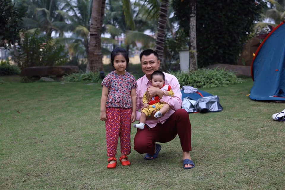 Ba bố con Tự Long chụp hình trên thảm cỏ trong căn nhà vườn rộng rãi của Xuân Bắc. Ảnh: Dân Việt.