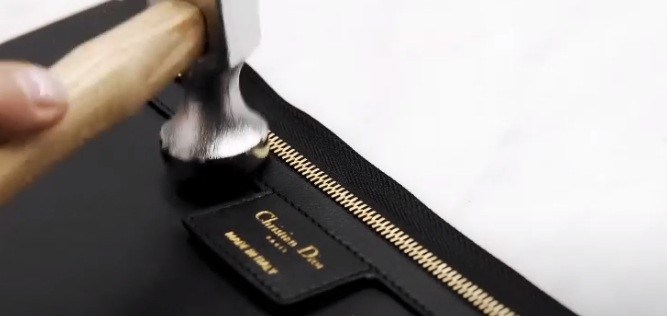 Dòng chữ vàng khắc tên thương hiệu "Christian Dior" được khâu cẩn thận.