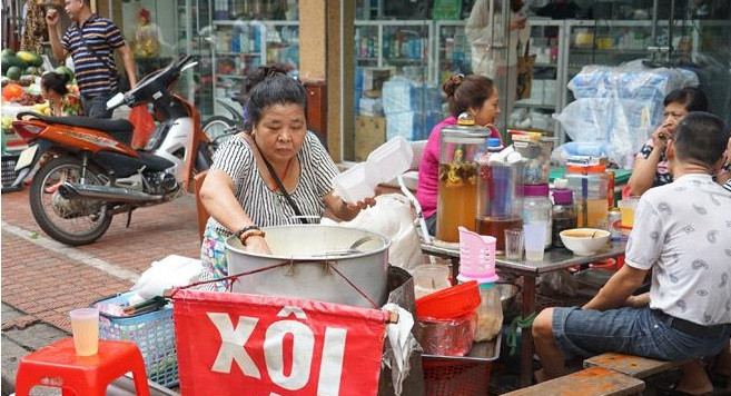 Quán xôi sắn vỉa hè chợ Ngô Sĩ Liên của cô Kim hay còn gọi hàng xôi sắn ông bà cụ là một trong những hàng hiếm hoi bán món ăn đặc biệt này ở Hà Nội. Ảnh: Khám phá.
