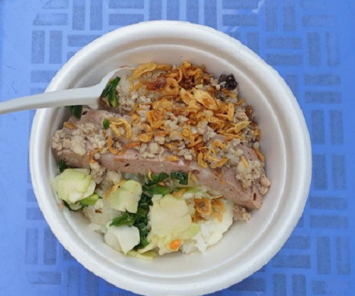 Quán xôi không có mái che, cũng không có bàn để khách hàng ngồi ăn, chỉ là chiếc bàn nhỏ bán trà đá và nồi xôi với lỉnh kỉnh chiếc cặp lồng sắt, bát nhựa đựng hành chưng, hành khô...Ảnh: Khám phá.