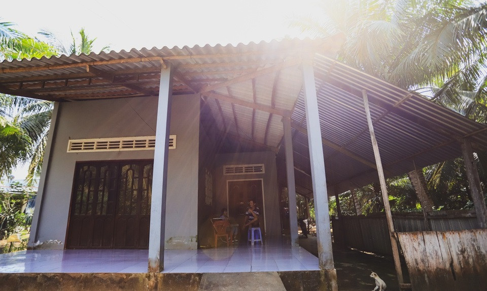 Để vào được nhà phải bước qua chiếc cầu ọp ẹp dựng tạm bằng gỗ và các bao cát bắc qua mương dẫn nước. Ảnh: Zing