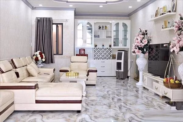 Ngôi nhà của Lê Dương Bảo Lâm gồm 1 trệt, 2 lầu và 1 sân thượng. Phòng khách mang tông trắng chủ đạo, được bài trí sang trọng với sofa đôi. Ảnh: Lao động