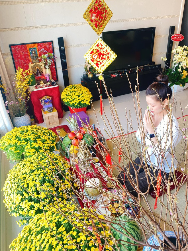 Vào dịp Tết, Hoa hậu Hoàn vũ Việt Nam Khánh Vân trang trí nhiều hoa cúc vàng nổi bật, hoa đào và các phong bao trang trí màu đỏ. Ảnh: Zing