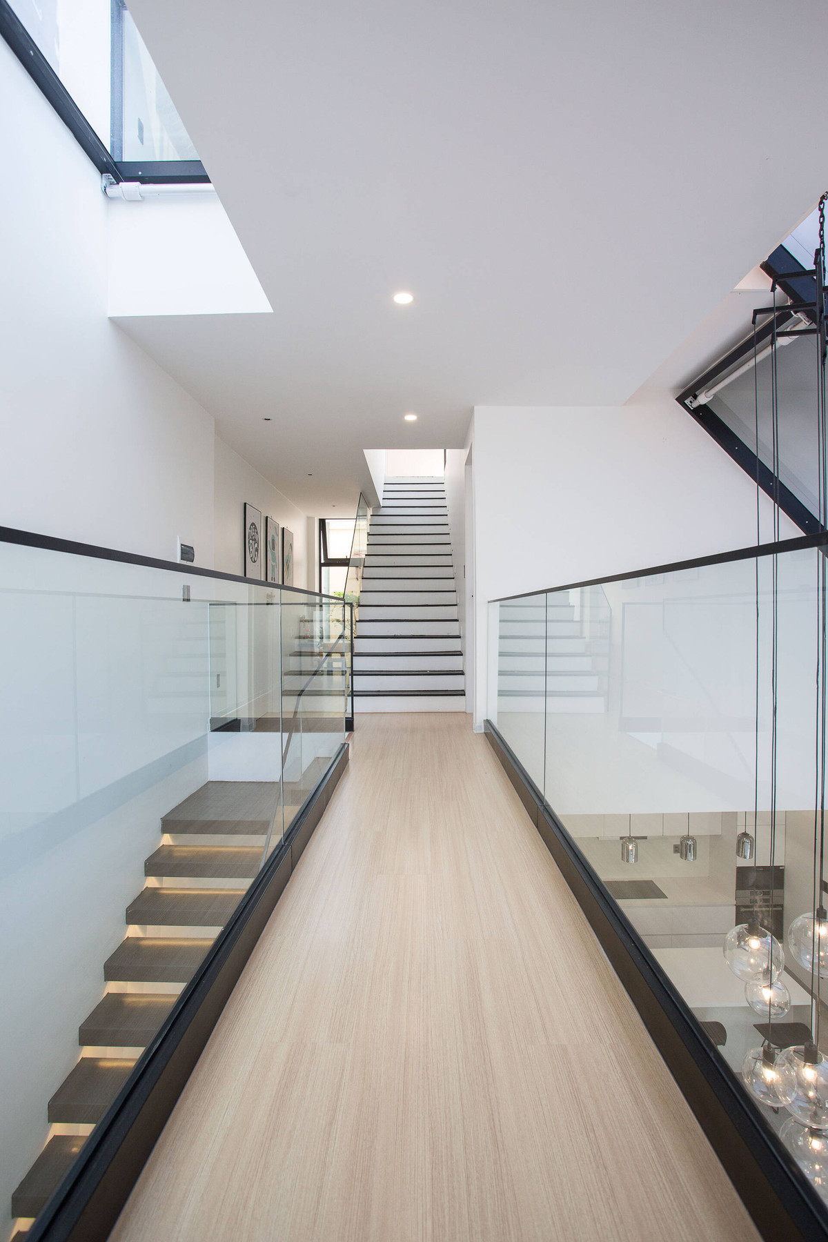 Hành lang dẫn đến không gian riêng ở tầng 2 có lan can kính làm từ kính cường lực.