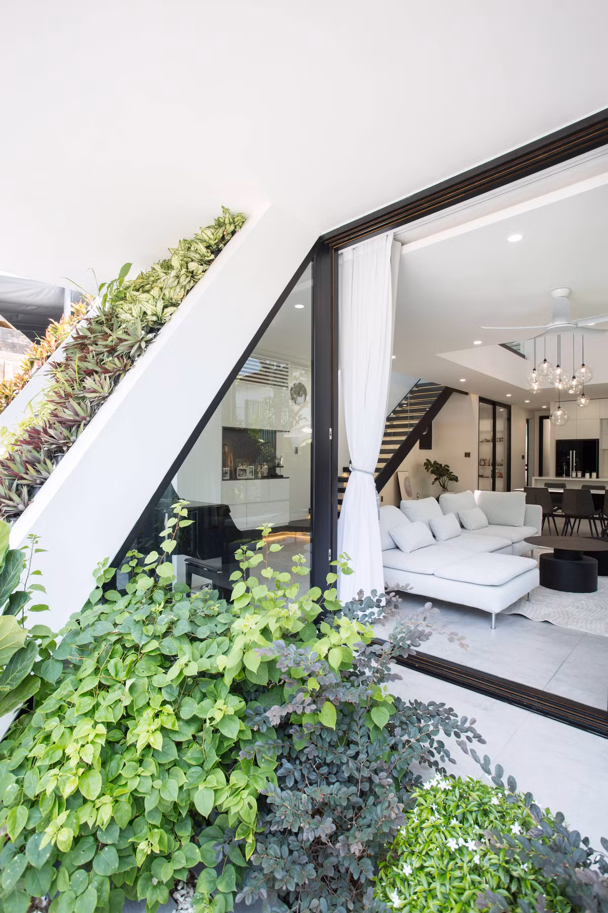 Tầng 1 là không gian sinh hoạt chung bao gồm phòng khách, bếp - ăn. Không gian dạng mở tạo cảm giác liền mạch với sân vườn.