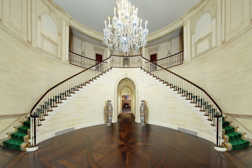 Tiền sảnh rộng nổi bật với chiếc đèn chùm tinh xảo và cầu thang đôi sang trọng.