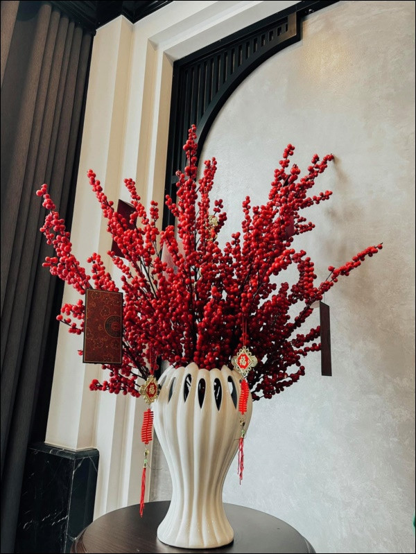 Ngoài ra, Phương Oanh còn tự tay cắm bình đào đông đỏ lớn trong phòng khách.