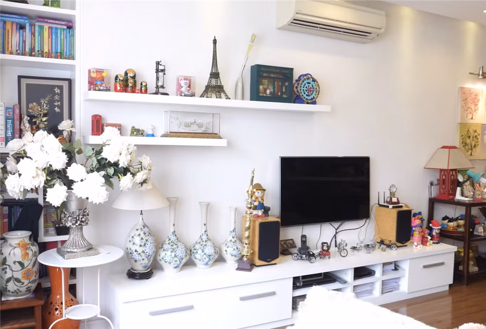 Đối diện với sofa phòng khách là kệ lớn giúp lưu trữ được các loại đồ lưu niệm và ti vi. Ảnh: Facebook