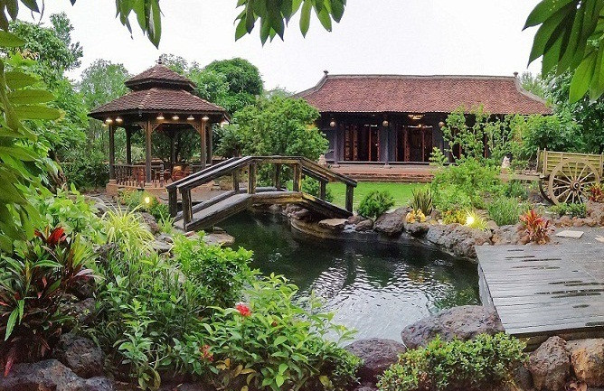 Khuôn viên trước nhà trồng các loại cây cảnh và thiết kế hòn non bộ tạo không gian thiên nhiên xanh mát. Ảnh: Vietnamnet.