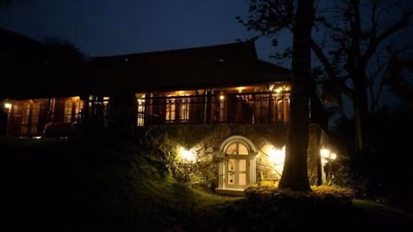 Nhà của Xuân Bắc được làm hoàn toàn bằng gỗ tự nhiên, có hiên nhà để thư giãn, có đường đi bằng đá xen giữa những thảm cỏ xanh non...