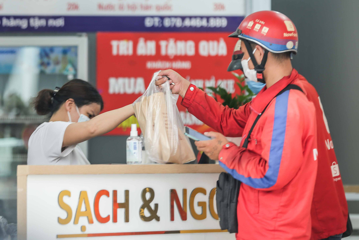 Dịch COVID-19 bùng phát trở lại khiến hoạt động kinh doanh bán lẻ thêm một lần nữa gặp khó khăn trong việc trao đổi, vận chuyển hàng hóa trực tiếp đến tay người tiêu dùng. Vì vậy, nhiều cửa hàng và đơn vị vận chuyển trong cái khó đã nghĩ ra những cách vô cùng độc đáo, thích ứng với tình hình chung. Ảnh: Người lao động