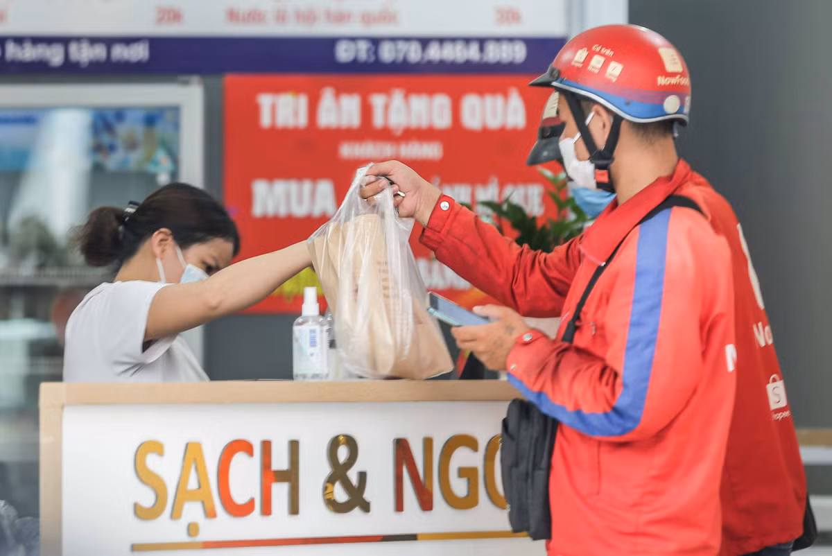 Dịch COVID-19 bùng phát trở lại khiến hoạt động kinh doanh bán lẻ thêm một lần nữa gặp khó khăn trong việc trao đổi, vận chuyển hàng hóa trực tiếp đến tay người tiêu dùng. Vì vậy, nhiều cửa hàng và đơn vị vận chuyển trong cái khó đã nghĩ ra những cách vô cùng độc đáo, thích ứng với tình hình chung. Ảnh: Người lao động