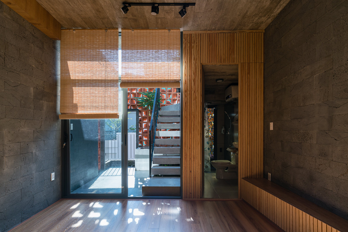 Việc tạo 2 lớp vỏ - double skin (gạch bánh ú và cửa lùa kính) không chỉ khiến nội thất công trình được đóng mở một chủ động với bên ngoài mà còn giảm nắng trực tiếp và hướng nhìn từ nhà đối diện.