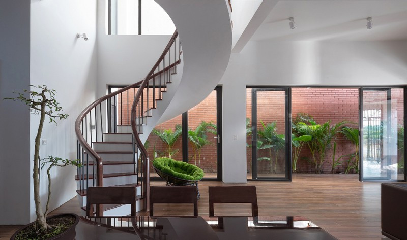 Cầu thang dẫn lên các tầng bằng gỗ cùng tông màu với nội thất khu vực phòng khách.