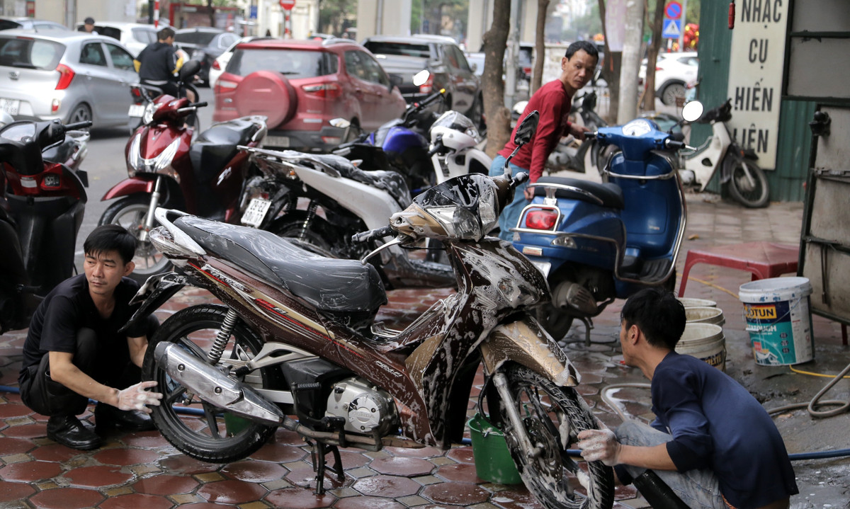 Dù công việc vất vả nhưng thu nhập ngày Tết luôn là động lực cho các nhân viên rửa xe. Ảnh: Báo giao thông.