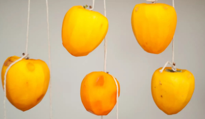 Sau đó, người ta buộc dây vào cuống quả và treo lên giá phơi, những quả nào không có cuống, có thể cài một chiếc đinh nhỏ thay thế.