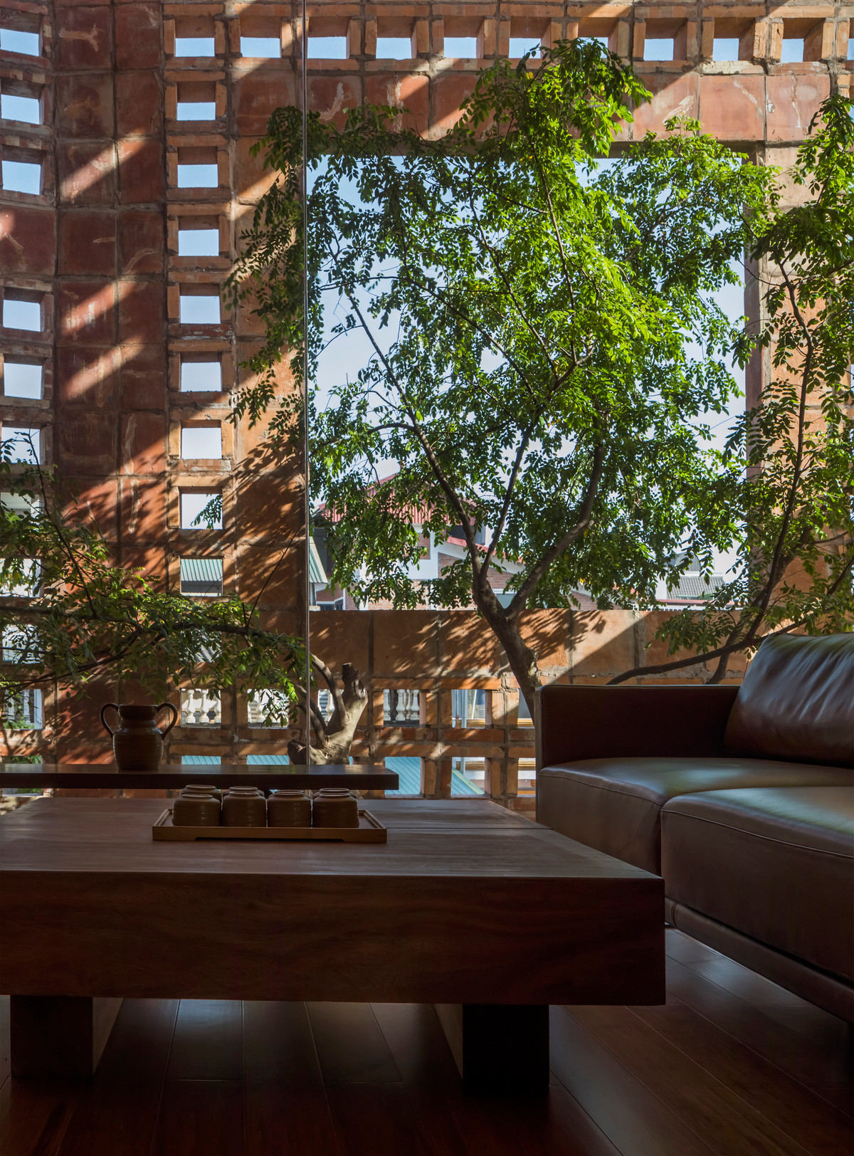 Việc kết hợp khung cửa kính và các lỗ thoáng trên bức tường gạch gốm có tác dụng lấy sáng hiệu quả mà không mang lại cảm giác quá nóng vào mùa hè.