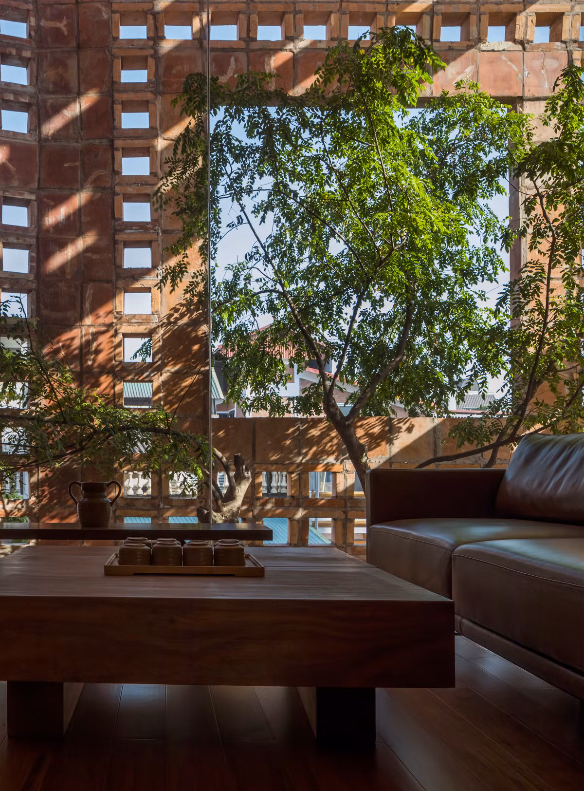 Việc kết hợp khung cửa kính và các lỗ thoáng trên bức tường gạch gốm có tác dụng lấy sáng hiệu quả mà không mang lại cảm giác quá nóng vào mùa hè.