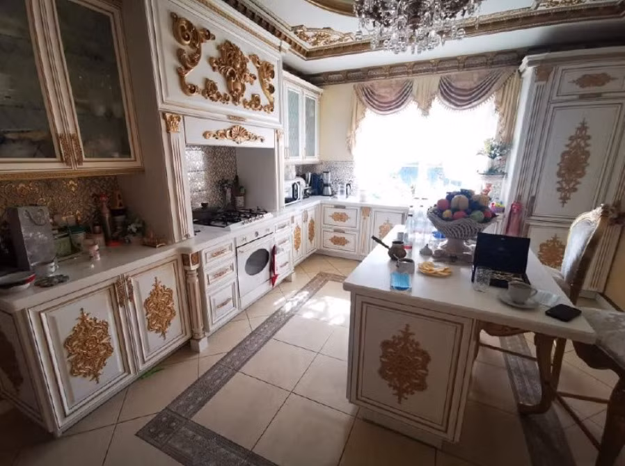 Khu bếp với gam màu trắng chủ đạo được tô điểm bằng các chi tiết dát vàng. Nguồn ảnh: Themoscowtimes.