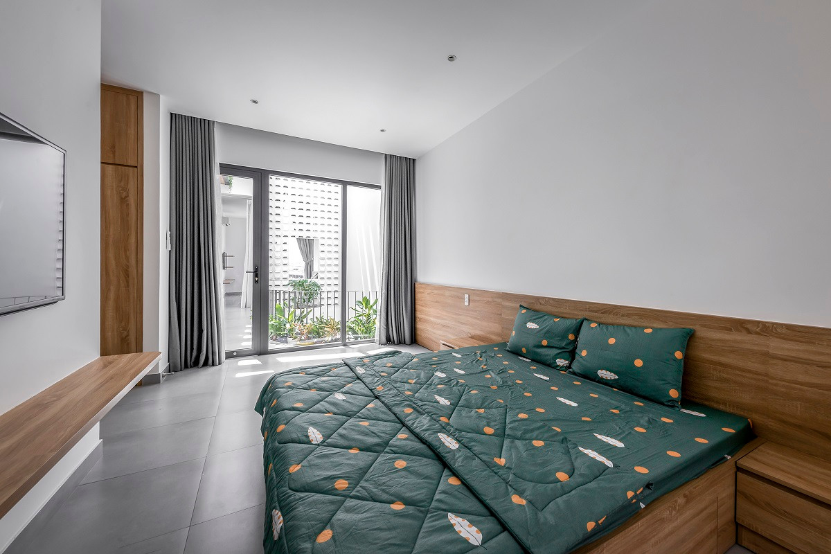 Vách phòng ngủ với mảng kính lớn nhìn ra giếng trời và mảng xanh giúp cho chúng ta thư giãn hơn khi ở trong phòng. Nguồn ảnh: Bùi Minh Quốc