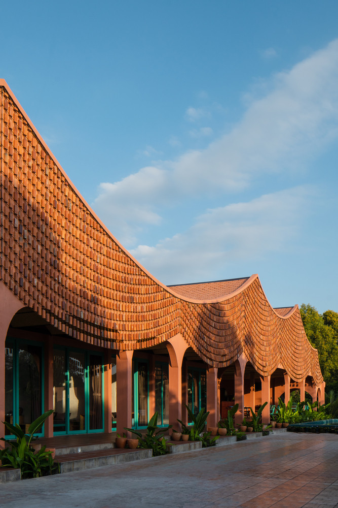 Lấy cảm hứng từ kỹ thuật đan thủ công mỹ nghệ, nhóm thiết kế sử dụng ngói, thanh thép tròn, gạch để “đan” thành những tấm rèm uốn lượn bao phủ 2 khối nhà.