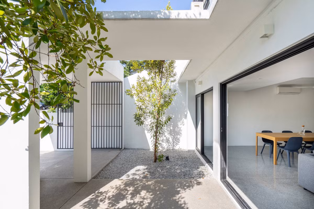 Khoảng đất trống cây được rải sỏi để phân tách với lối vào nhà.