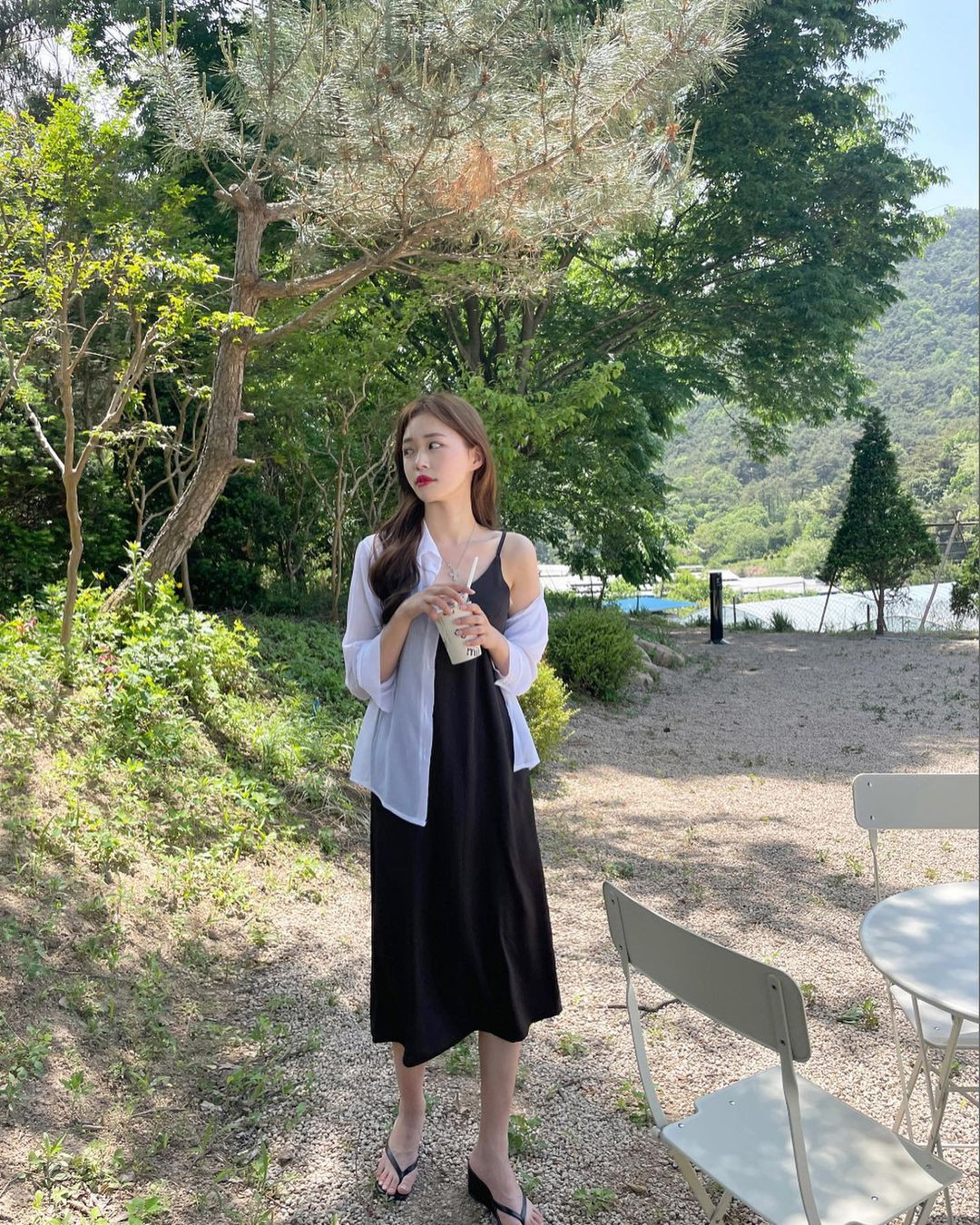 Còn khi đi chơi, dạo phố, bạn có thể khoắc áo sơ mi xuyên thấu bên ngoài váy hai dây.