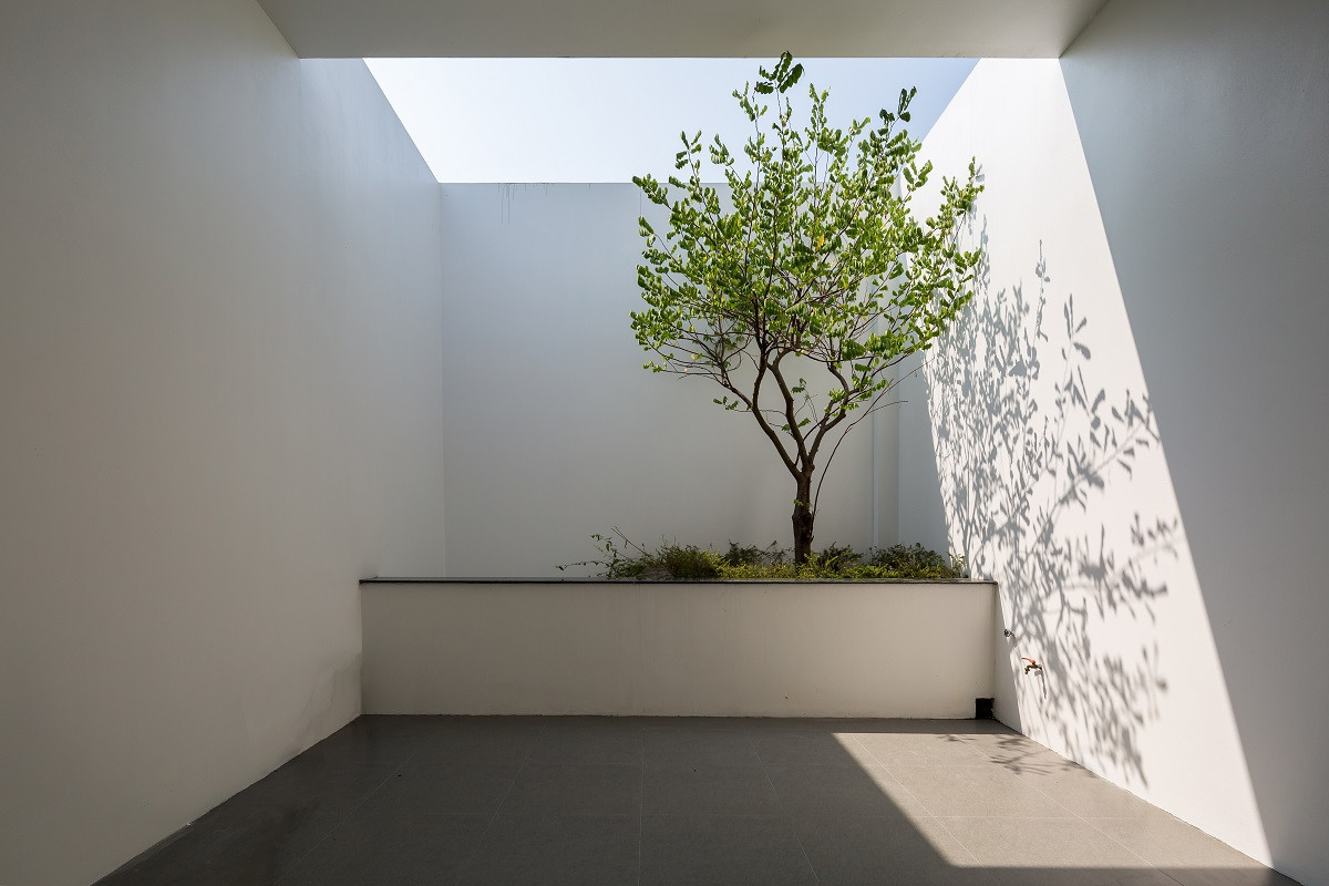 Một giếng trời nhỏ được bố trí phía sau nhà giúp đảm bảo sự cân bằng cảnh quan giữa các tầng, giúp tăng khả năng đối lưu gió, làm mát không gian, tăng tính kết nối và giúp thoát hiểm nhanh hơn khi gặp sự cố. Nguồn ảnh: Hoang Le.