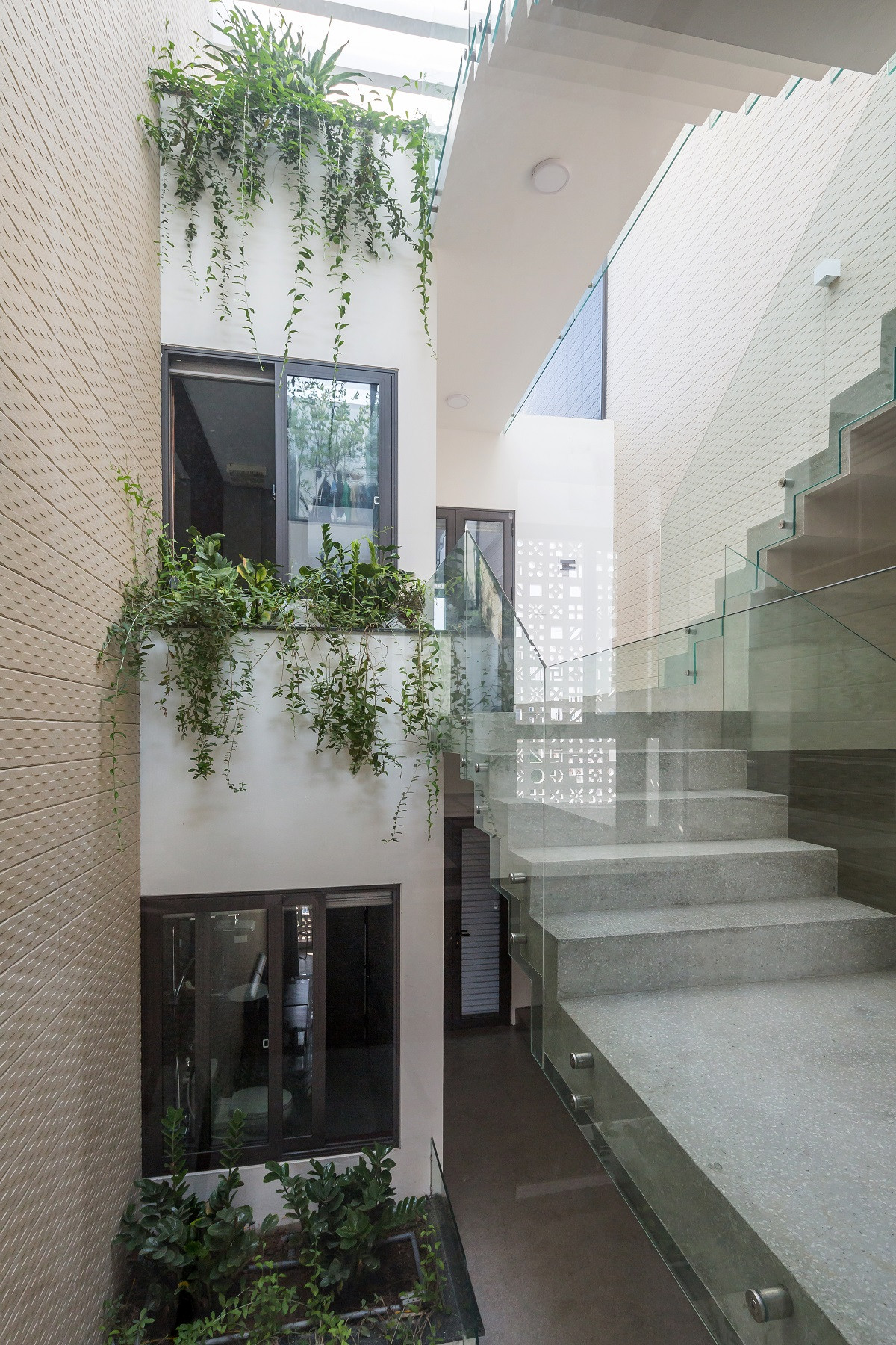 Giếng trời giữa nhà có xu hướng mở rộng hơn ở các tầng trên giúp kết nối nhiều không gian từ phòng ngủ, cầu thang và sân phơi tốt hơn.