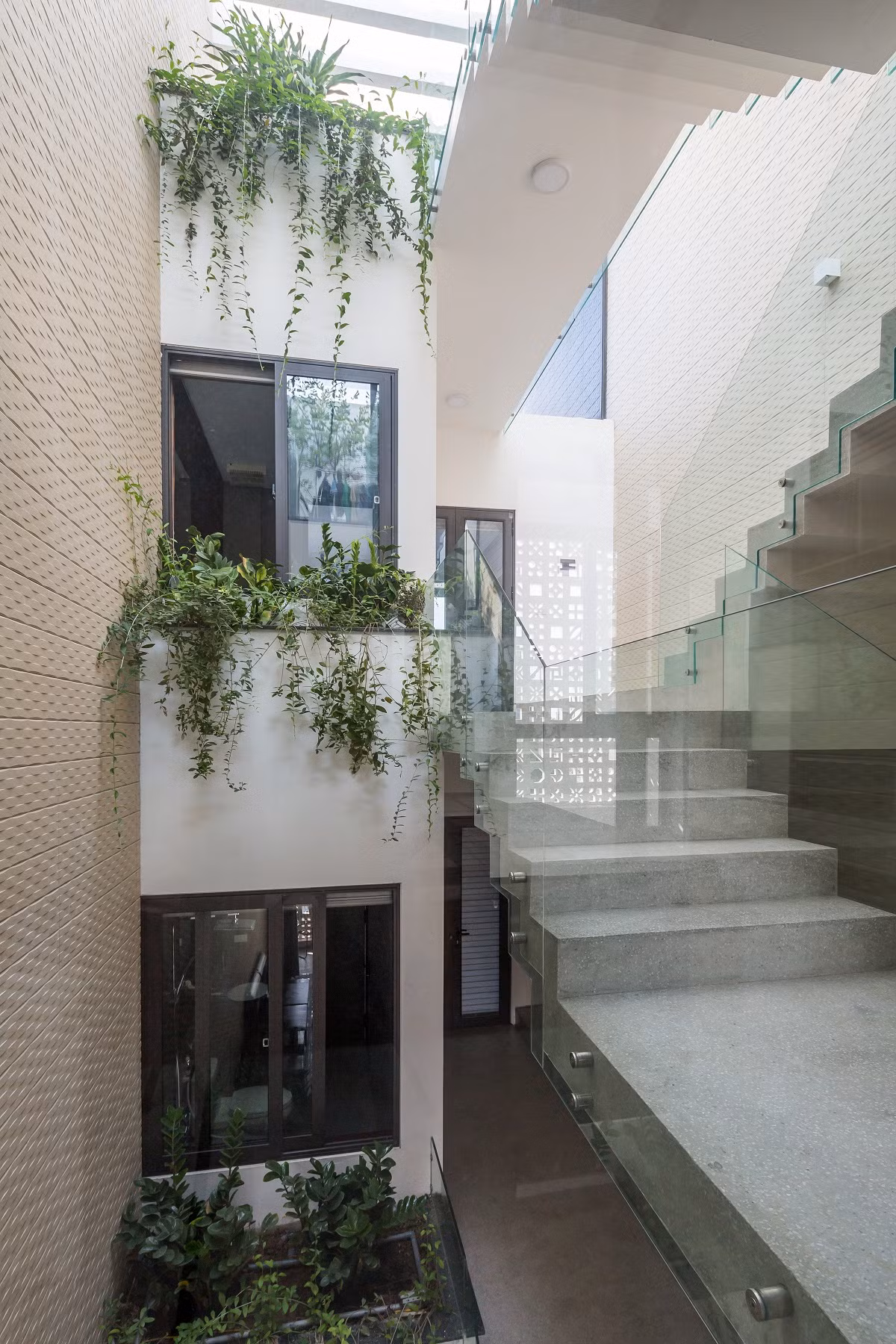 Giếng trời giữa nhà có xu hướng mở rộng hơn ở các tầng trên giúp kết nối nhiều không gian từ phòng ngủ, cầu thang và sân phơi tốt hơn.