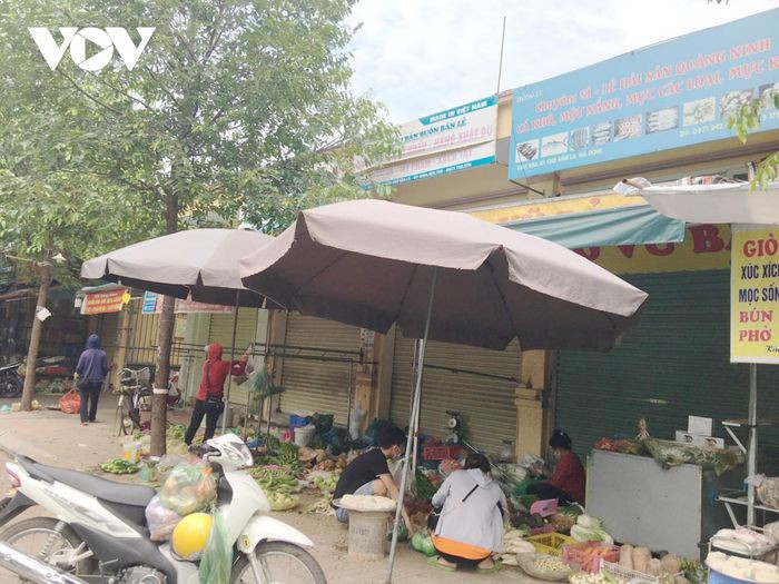 Sau khi Chỉ thị 16 được áp dụng, rất đông các cửa hàng, ki ốt không thiết yếu ở chợ chính Văn La đóng cửa tạm dừng buôn bán, thì các hộ dân kinh doanh rau, củ quả, thực phẩm sống “tranh thủ” dọn hàng bán trên vỉa hè.