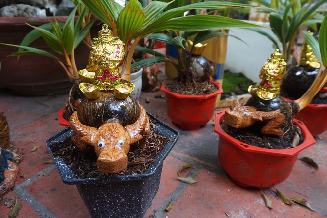 Chú trâu được cách điệu, "cõng" trên lưng là cây dừa và thỏi vàng khiến nhiều khách thích thú. Ảnh: Tiền phong.