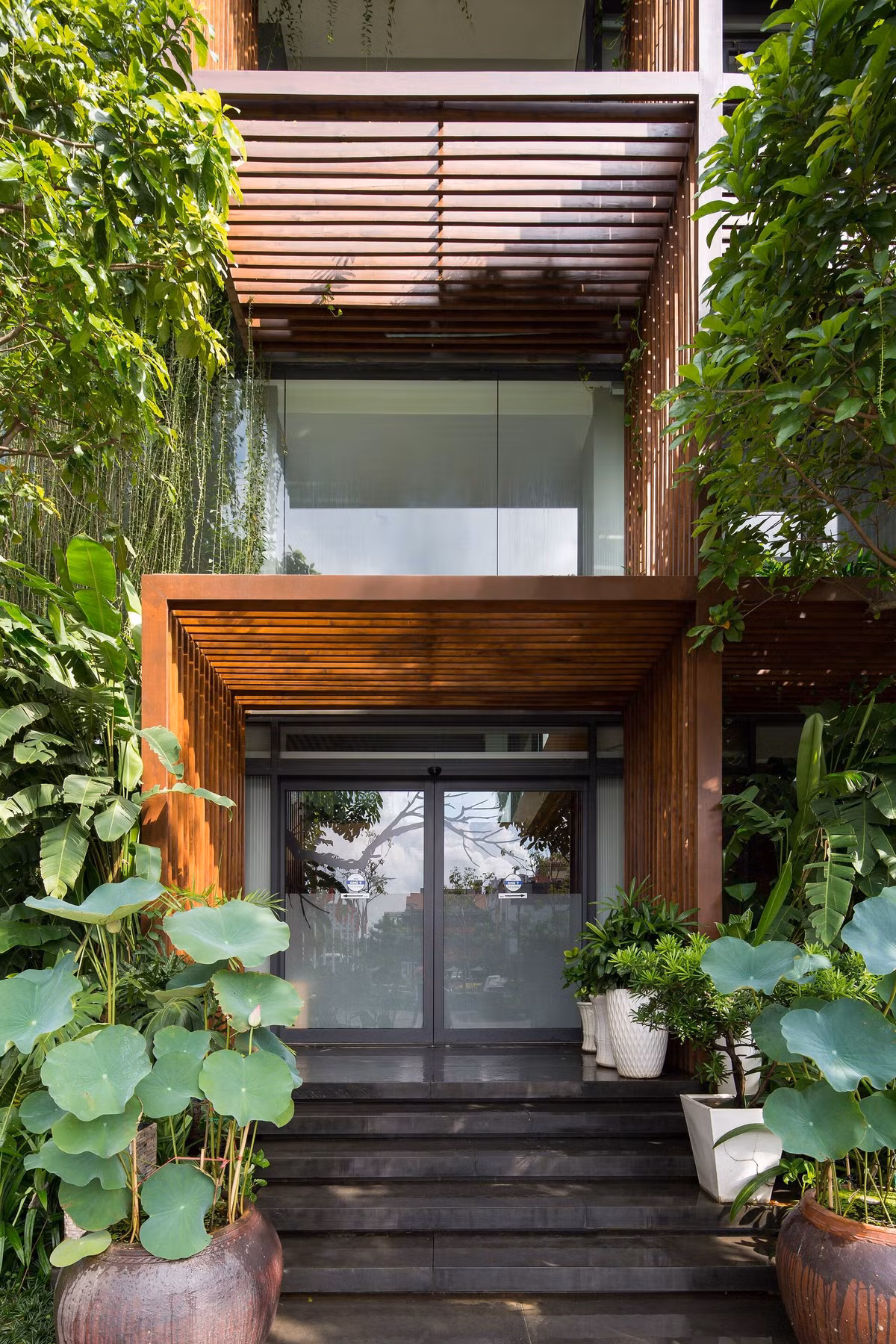 Cổng vào tòa nhà cũng rợp bóng cây xanh.