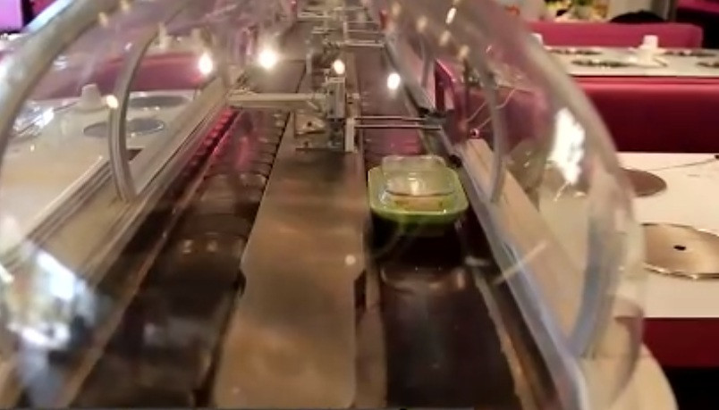 Sau khi chế biến, món ăn được chuyển tới bàn ăn băng chuyền hiện đại. Ảnh: SCMP