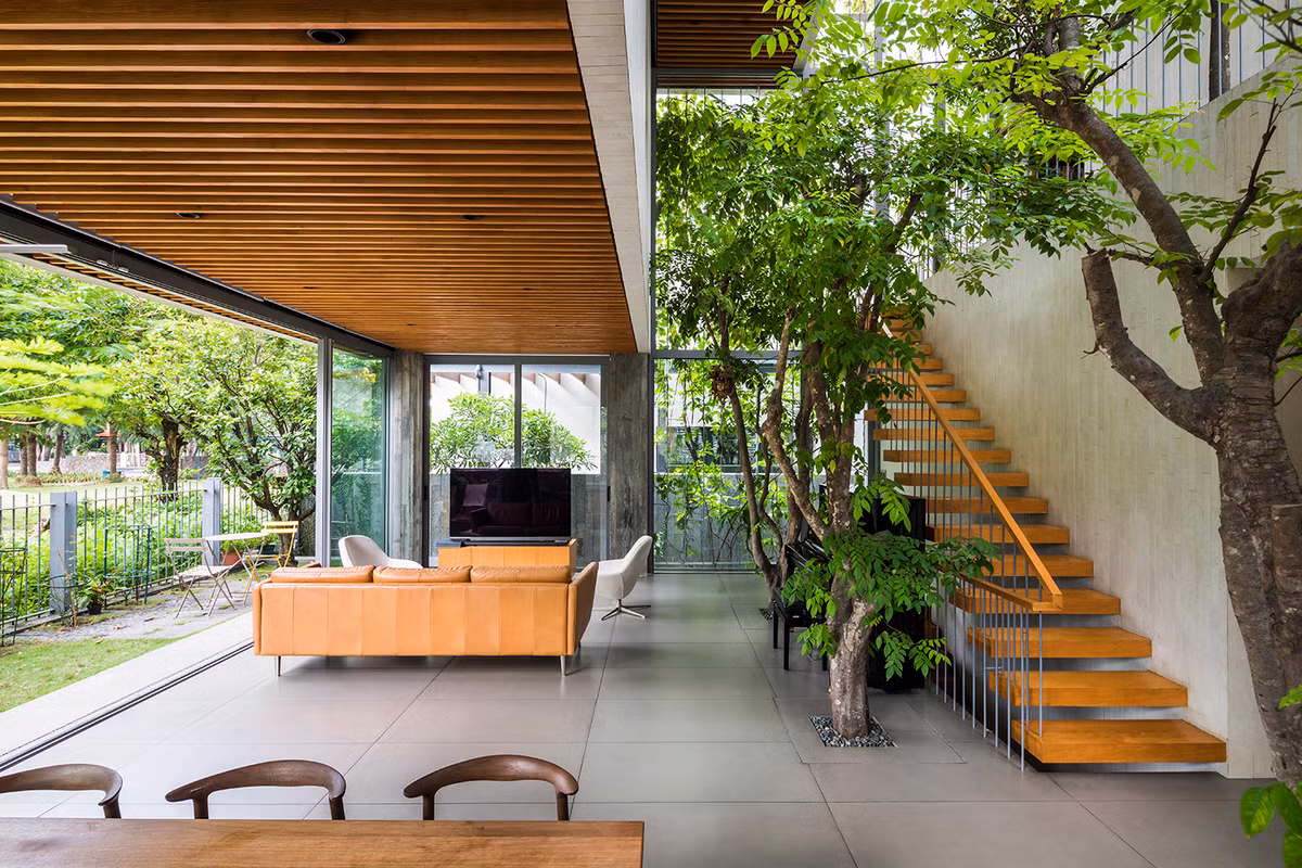 Phòng khách ở tầng trệt được thiết kế theo hướng mở, giao hòa với cây cối bên ngoài.