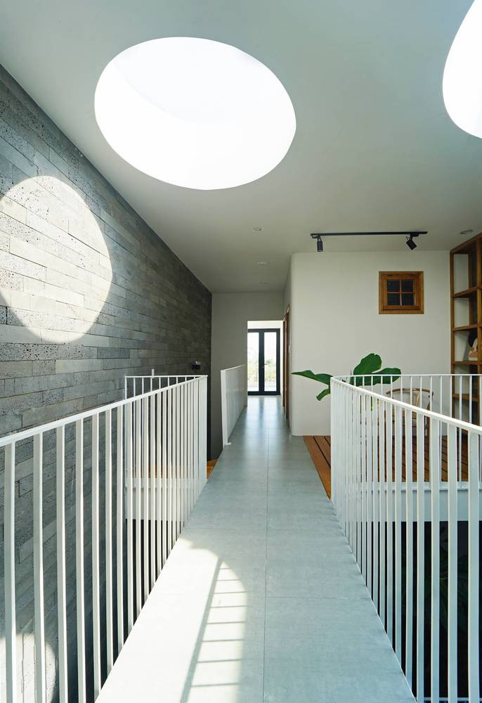 Việc kết hợp các gam màu trung tính xung quanh khoảng thông tầng có tác dụng điều hòa nhiệt độ bên trong ngôi nhà một cách đáng kể.