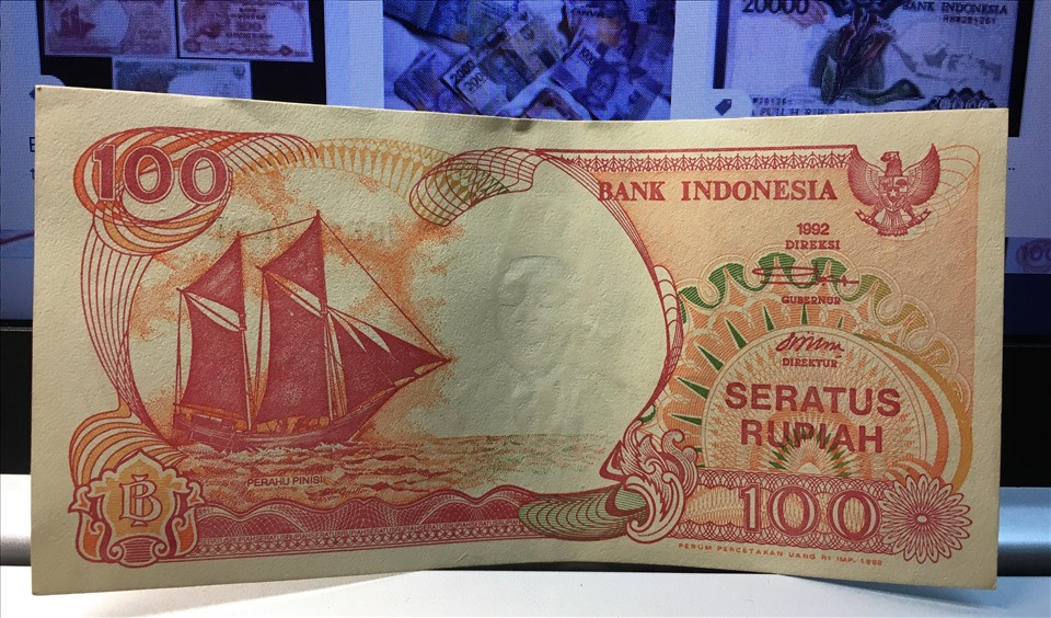 Tờ 100 rupiah Indonesia được nhiều người gọi vui là “hoa hậu tiền giấy” bởi màu đỏ rực rỡ. Mặt sau của tờ tiền in hình cánh buồm tượng trưng cho “thuận buồm xuôi gió”. Ảnh: Lao động.